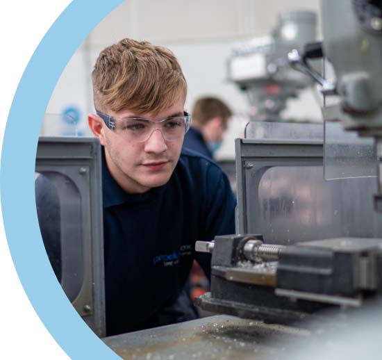 Keighley College apprentice wearing safety goggles using a pillar drill