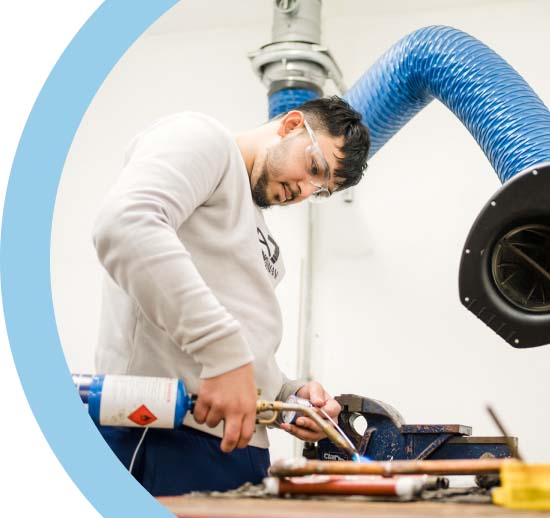 Apprentice at Keighley College wearing safety goggles using a blow torch