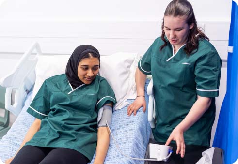 Health care students in medical uniform learning how to take blood pressure