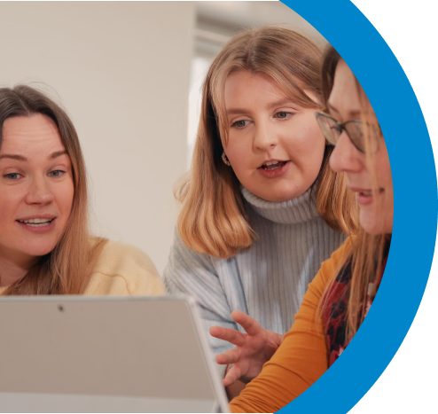 Three people all looking with interest at a laptop screen