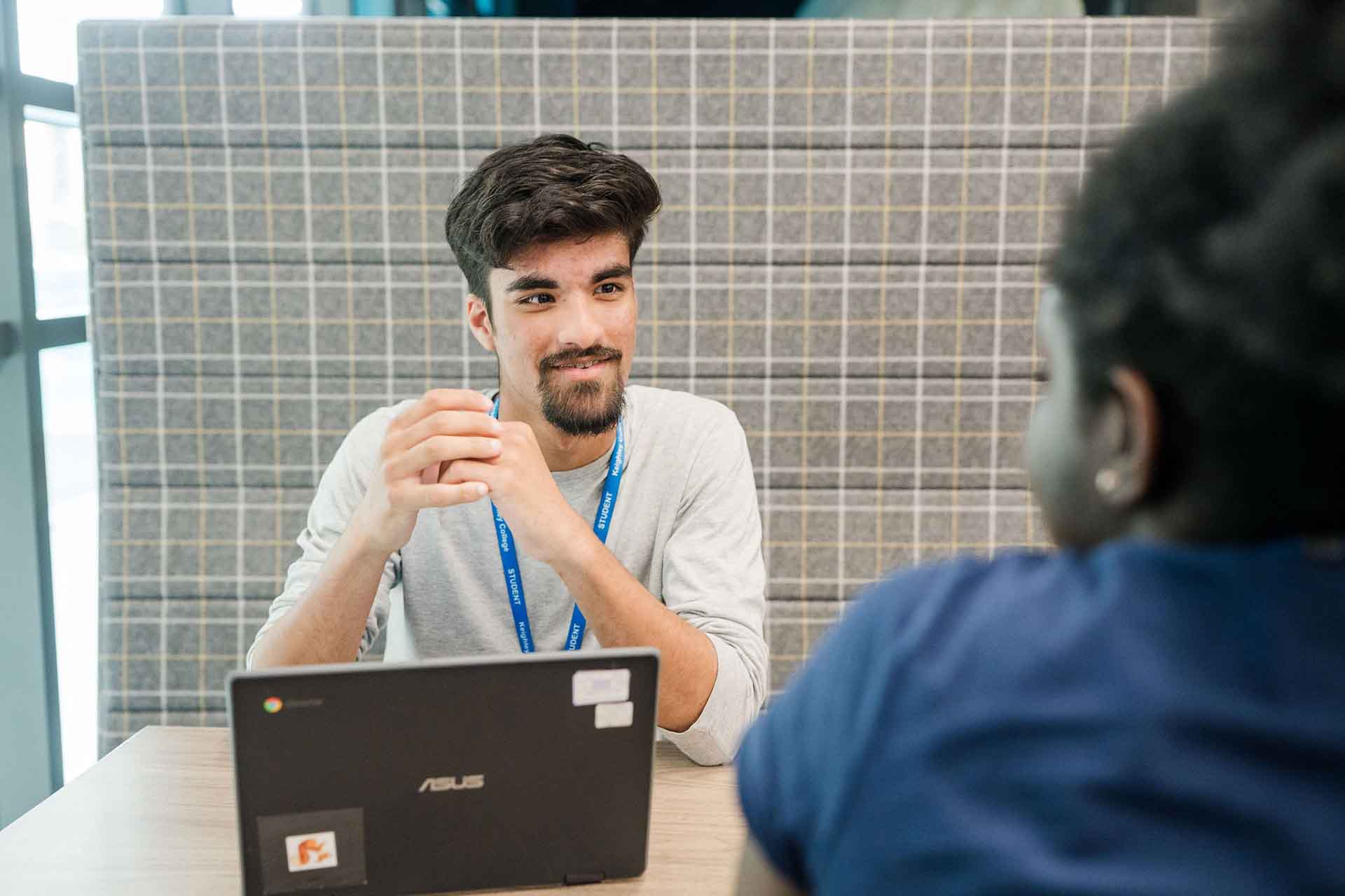 Students sitting down with laptop having discussion